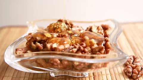 Honey is poured on walnuts Stock Footage 146839905