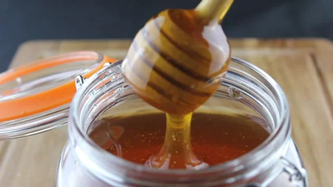 Honey pouring into jar HD Stock Footage 168960752
