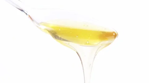 Honey running from plastic spoon Stock Footage 8571613
