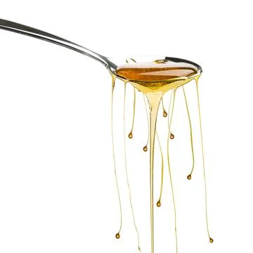 Honey on spoon Stock Photos