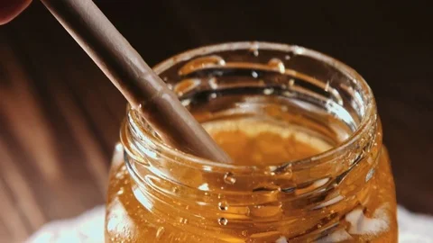 Honey stick getting out of jar 스톡 동영상 69996976