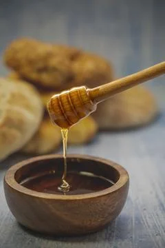 Honey on table with bread in the background. Stock Photos