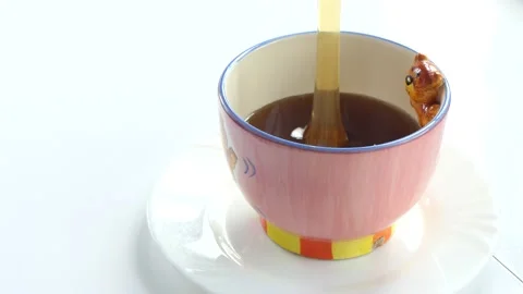 Honey trickles down into a standing Cup . Stock-Footage 135648842