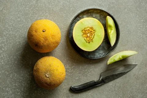 Honeydew melon on a grey background. Stock Photos