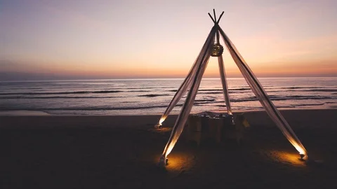 Honeymoon dinner table set for couple on sunset beach in luxury hotel Video stock 98840991