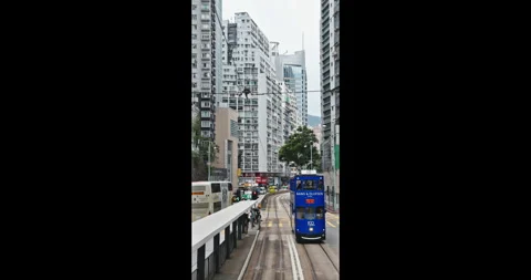 Hong Kong double-decker tram moving on urban city street Stock Footage 344692688