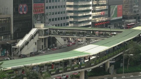 Hong Kong - Elevated view of people on footbridge and traffic in city centre. 4K Stock Footage 81099389