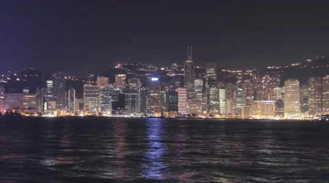 Hong Kong at night: Time-lapse camera pan of skyline of office blocks in harbor  Stock Footage 63909121