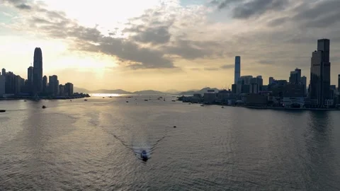 Hong Kong at sunset, fly over boat heading towards drone Stock Footage 337093554