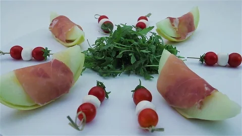 Honig melon and ham with rucola and bunches of tomatoes Stock Footage 81480622