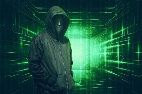 Hooded with anonymous mask standing with binary code 库存照片