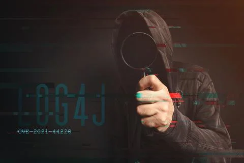 Hooded computer hacker in cybersecurity vulnerability Log4J concept Stock Photos