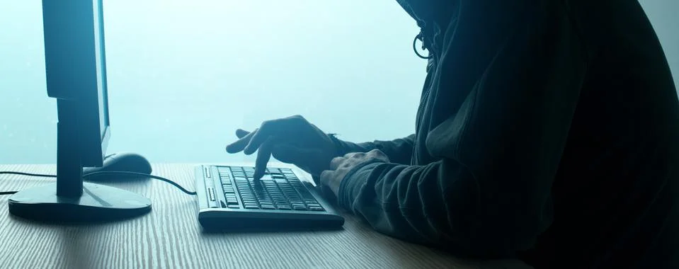 Hooded computer hacker hacking network Stock Photos