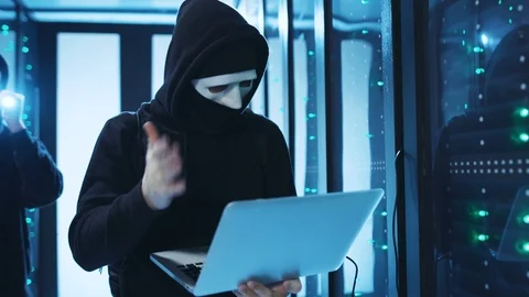 Hooded computer hacker working on code trying to login into system or steal Stock Footage 120694746