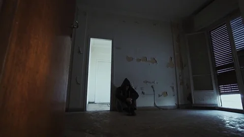 Hooded depressed young man in empty abandoned house Vidéo 72936410