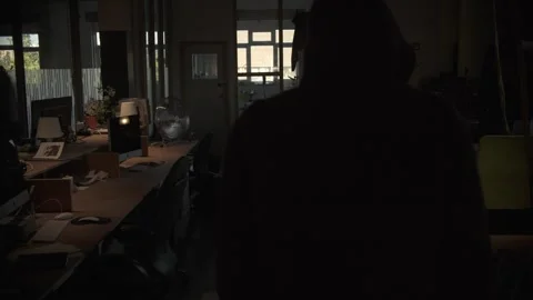Hooded Figure Walking Through Dark Office Stock Footage 344625574