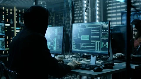 Hooded Hacker and His Group Break into Corporate Data Servers.  Stock Footage