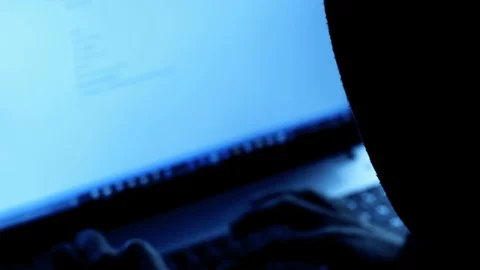 Hooded  Hacker attacking computer system in a dark office Stock Footage 90078143
