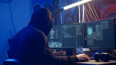 Hooded hacker creating pirating crack for software and video game releases 写真素材