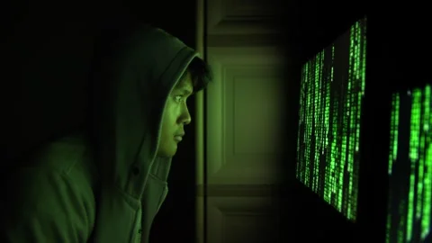Hooded Hacker Facing Digital Code Screen in Dark Cyber Environment Stock Footage 336441828