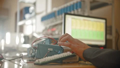 Hooded hacker operating electronic equipment in lab Stock Footage 347726180