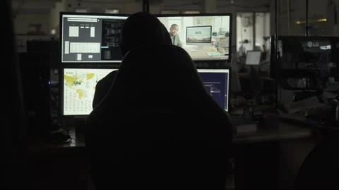 Hooded Hacker Typing Code on Multiple Computer Monitors Video stock 344625064
