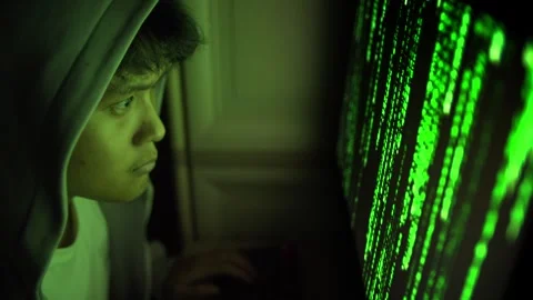 Hooded Hacker Using Computer With Green Code at Night Stock Footage 336475073