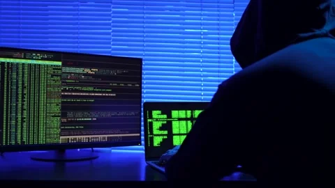 Hooded hacker using laptop computer, close-up. Anonymous hacker sitting in .. Stock Footage 288979581