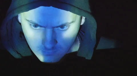 Hooded hacker working on a computer, binary code projecting on his face Video stock 64818317