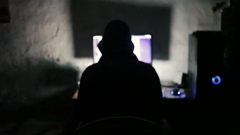 Hooded human working on a computer with all lights off at late night.Haunted. Stock Footage 104258053