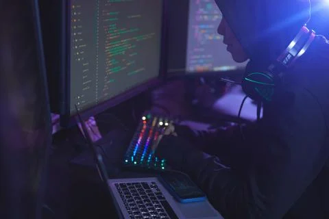 Hooded Man Coding in Dark Stock-Fotos