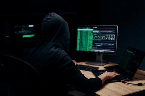 Hooded man hacking servers Stock Photos