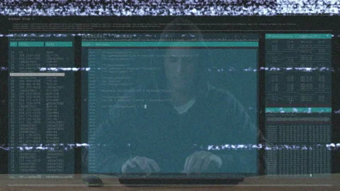 Hooded man typing deploy command for microscope Stock Footage 313241245