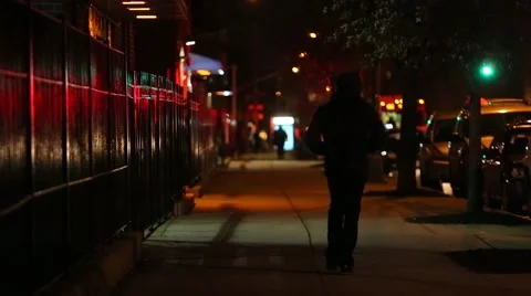 A hooded man walks on the street at night Brooklyn New York Stock Footage