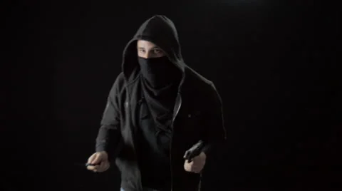 Hooded Masked Man Pulls Handgun and Knife Out of His Sweatshirt Stock Footage 61247350