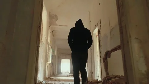Hooded young man inside destroyed building,slow motion,dramatic drone shot Stock-Footage 80069476