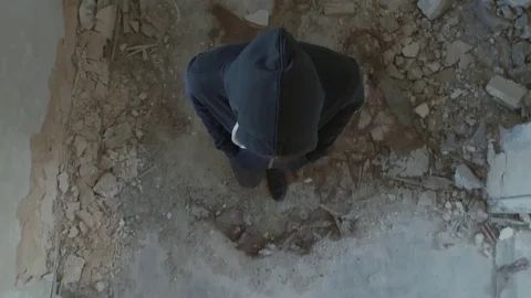 Hooded young man inside destroyed building,slow motion, bird eye view shot Stock Footage 80069765