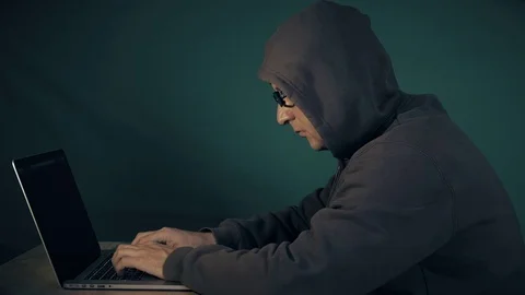 Hoody Man Coding. Profile side view of white man sitting at table and typing at 스톡 동영상 82727023