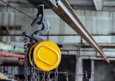 Hook on a beam crane for lifting and moving cargo in production rooms. Stock Photos