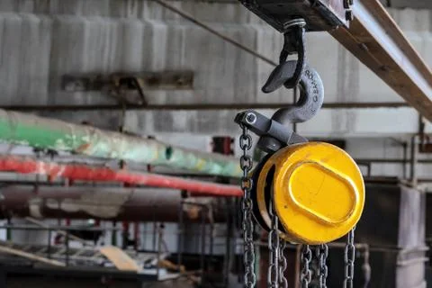 Hook on a beam crane for lifting and moving cargo in production rooms. Stock Photos