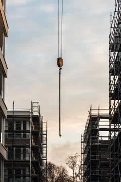The hook of the crane between the new house and the scaffolding Foto stock