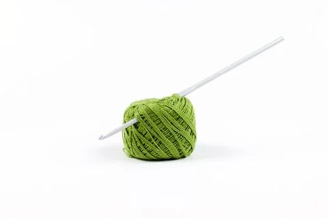 The hook is inserted into a ball of green thread. Knitting. Isolate on a white Stock Photos
