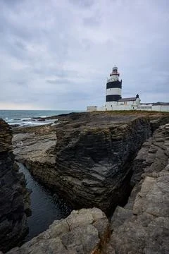Hook Lighthouse landscape with cliffs and waves and peninsula Heritage center Stock Photos
