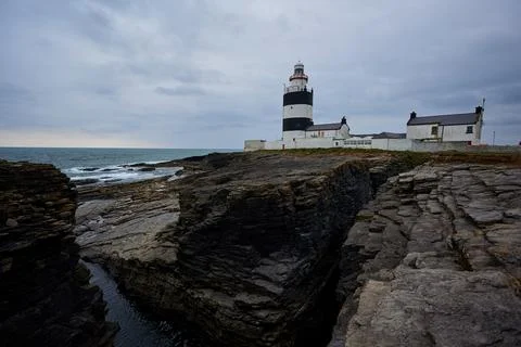 Hook Lighthouse landscape with cliffs and waves and peninsula Heritage center Stock Photos