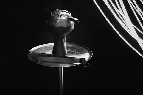 Hookah on a black background next to the glare from the lantern. Stock Photos