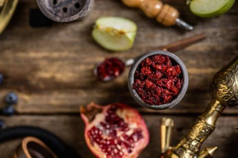Hookah components on a rustik old wood table with fruits, tobacco and cocoa c Stock Photos
