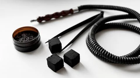 Hookah essentials: charcoal cubes, hose, and accessories on white background Stock Photos