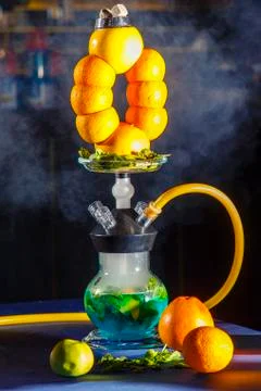 Hookah on the orange. Orange hookah. Hookah with a round transparent flask in Stock Photos
