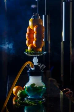 Hookah on the orange. Orange hookah. Hookah with a round transparent flask in Stock Photos