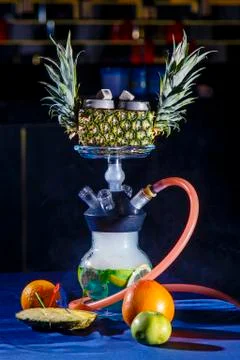 Hookah on pineapple. Pineapple hookah. Hookah with round clear bulb in which Stock Photos